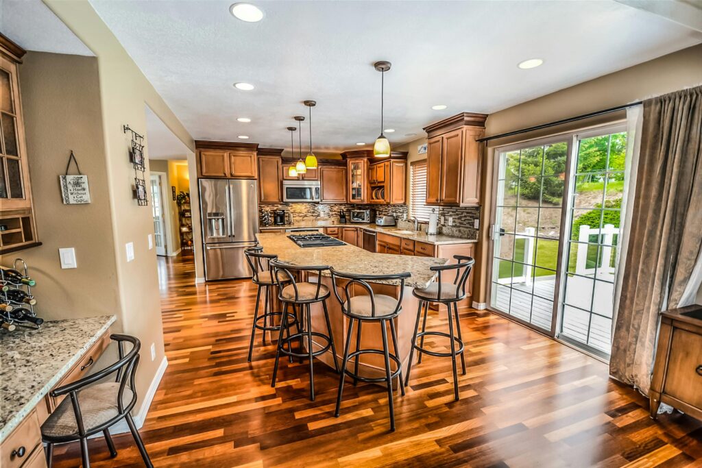 A luxurious modern kitchen featuring hardwood floors and granite countertops.